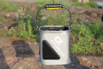 Portable fishing bucket with handle on a natural background