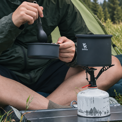 camping site with cooking equipment and a person enjoying outdoor meal.
